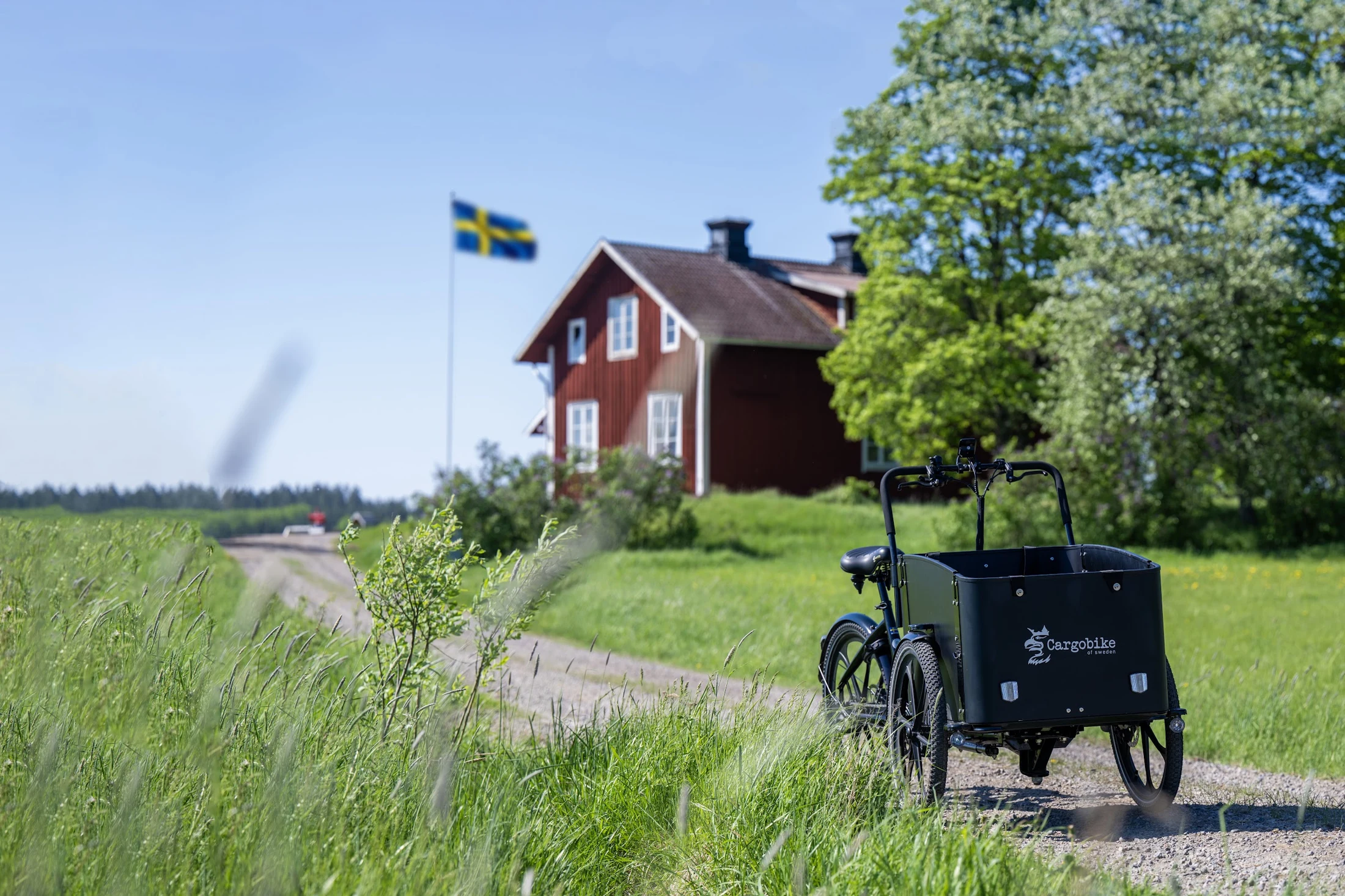 Cargo bike by a traditional red Swedish house